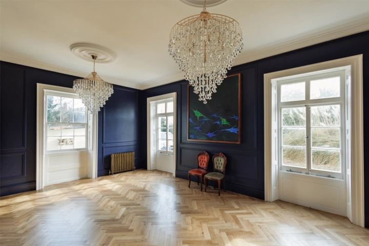 Contemporary art gallery with herringbone floor and chandeliers