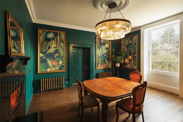 Dining room in Georgian house, green panelling and decorative artwork 