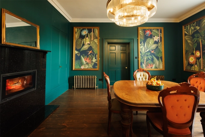 in Georgian house, green panelling and decorative artwork with recessed fireplace and decorative chandelier