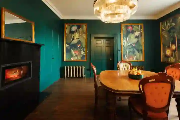 in Georgian house, green panelling and decorative artwork with recessed fireplace and decorative chandelier