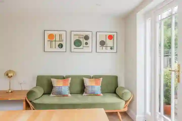 Modern green sofa with modern art on walls as part of kitchen diner
