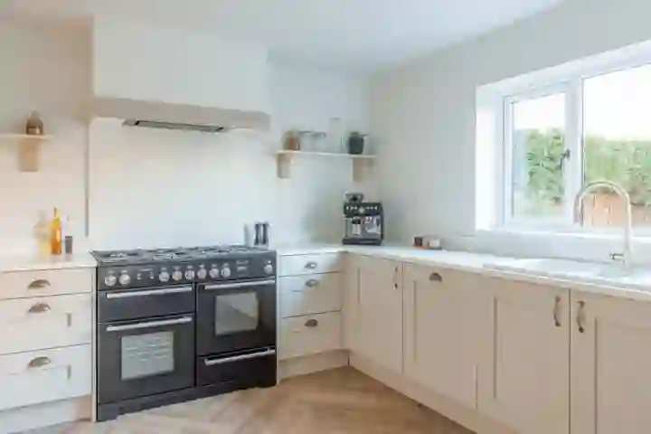 Close-up of shaker-style grey cabinets with soft-close drawers and stainless steel handles.