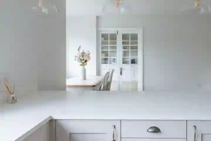 Modern kitchen island with white quartz surface, built-in induction cooktop, and pendant lighting overhead