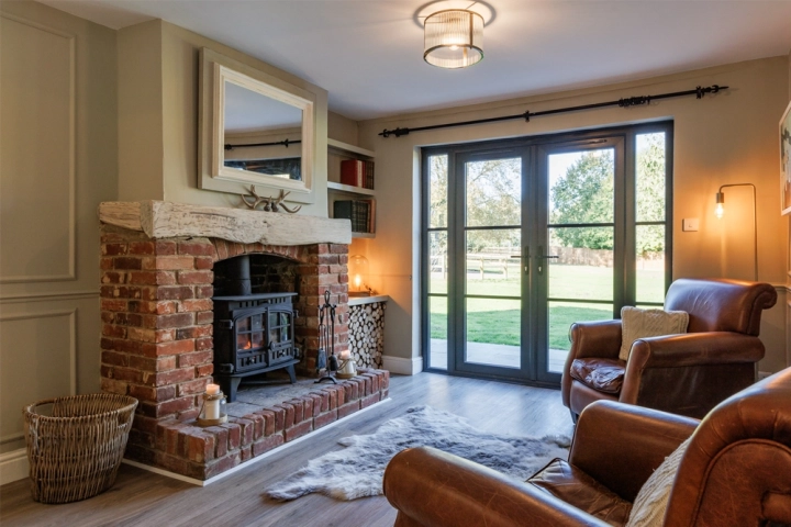 Country longue/diner with bi-fold doors and exposed brick fireplace