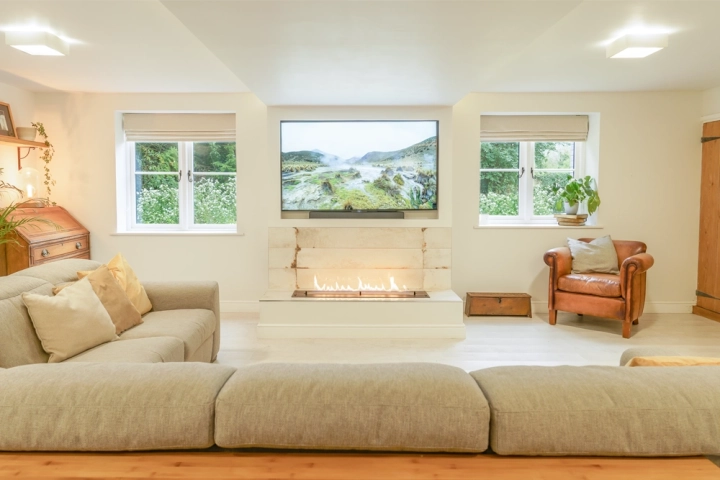 Home office with bioethanol fire below a media wall between two windows