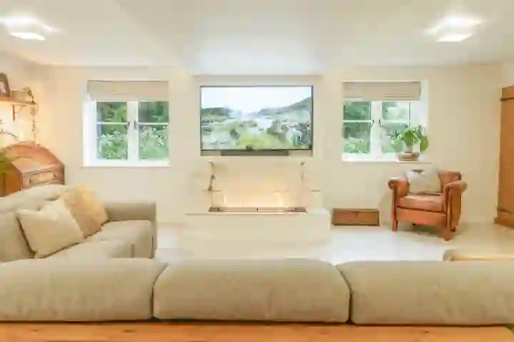Home office with bioethanol fire below a media wall between two windows