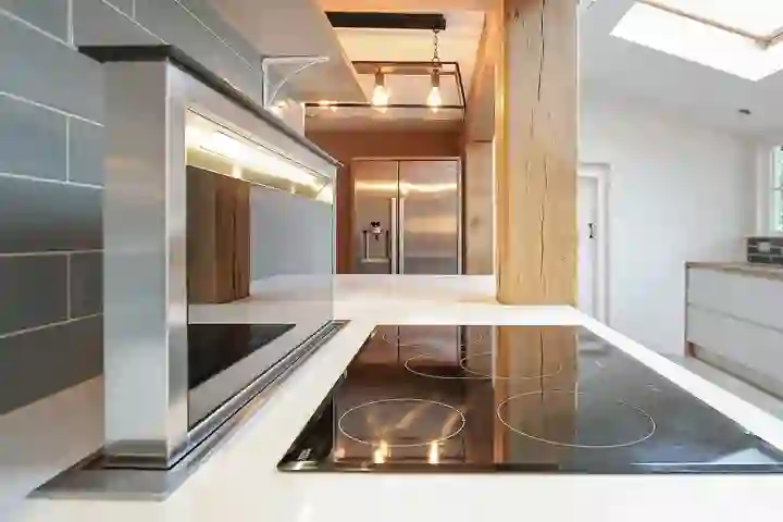 Contemporary kitchen with oak beams close up of integrated hob and electric extractor
