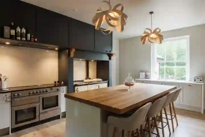 Contemporary kitchen with oak beams close up of integrated hob and electric extractor