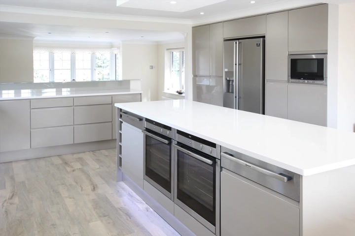 Modern kitchen with built in oven, white countertops and built in fridge/freezer