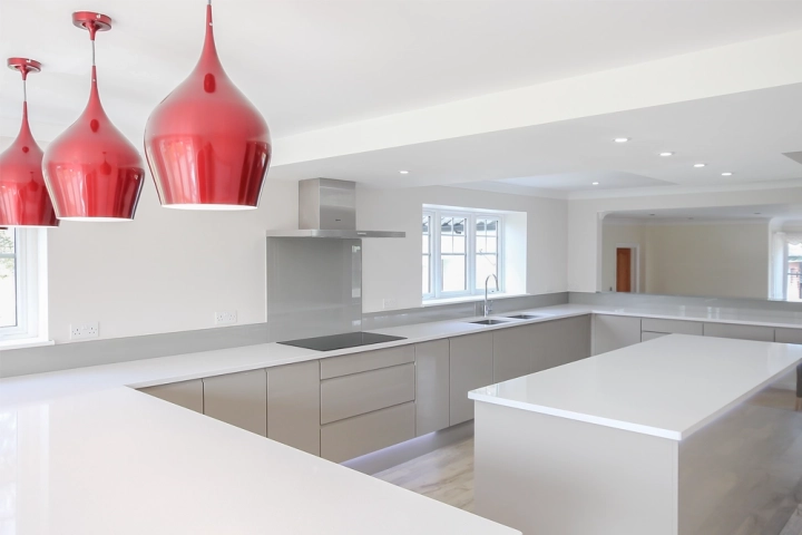 White and crome modern kitchen with red pendant lights