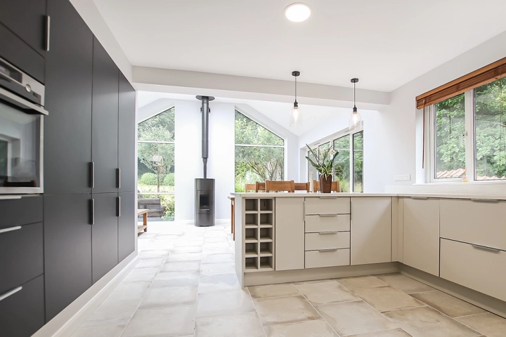 Modern kitchen with in built appliances and wood burning stove