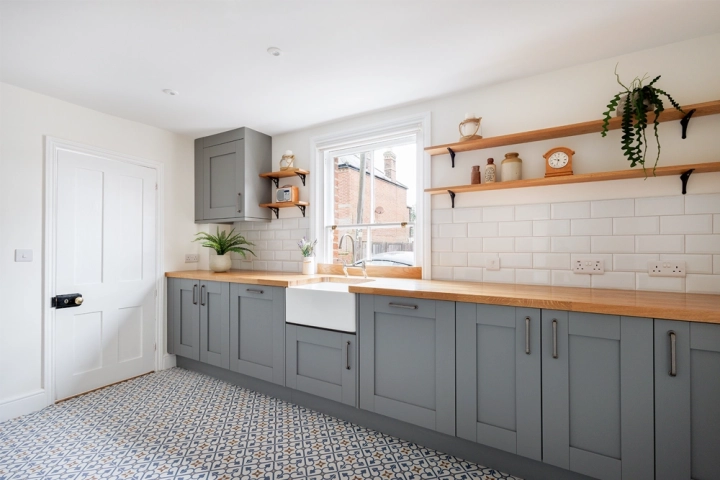 Traditional kitchen with grey/blue cabinets and patterned tiled floor