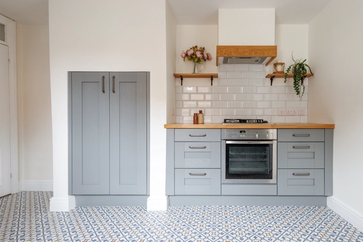 Traditional kitchen with open oak shelves and tall built in cupboards